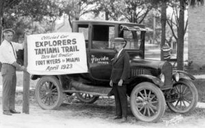 Explorers Tamiami Trail sign in front of an old automobile